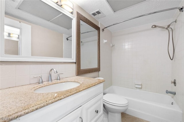 full bathroom featuring tiled shower / bath, decorative backsplash, vanity, toilet, and a textured ceiling