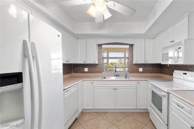 kitchen featuring sink, light tile patterned floors, white cabinets, and white appliances