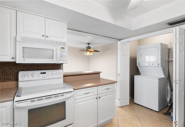 kitchen with stacked washer / dryer, white cabinetry, ceiling fan, and white appliances