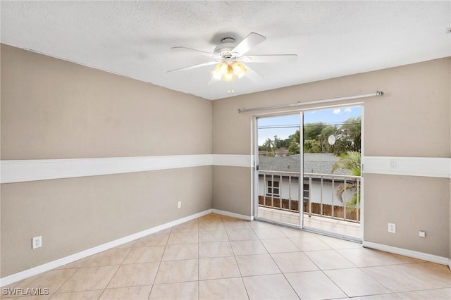 spare room with ceiling fan, a textured ceiling, and light tile patterned floors