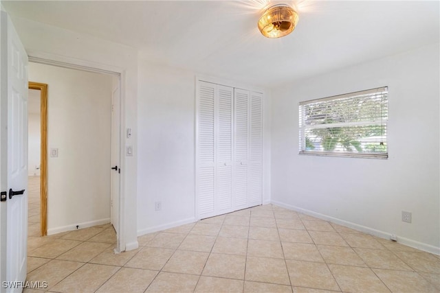 unfurnished bedroom with light tile patterned floors and a closet