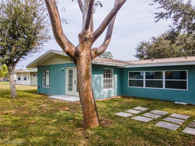 rear view of property featuring a lawn