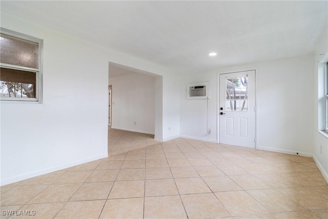 empty room with light tile patterned floors and a wall unit AC