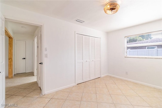 unfurnished bedroom with a closet and light tile patterned flooring