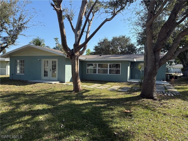 back of property featuring french doors and a yard