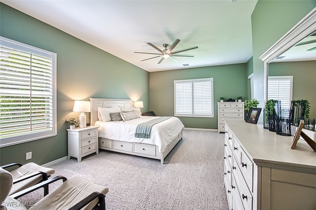 carpeted bedroom featuring ceiling fan and multiple windows