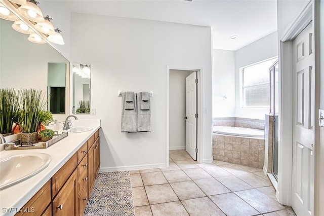 bathroom featuring a relaxing tiled tub, vanity, and tile patterned flooring