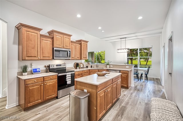 kitchen featuring hanging light fixtures, sink, a kitchen island, light hardwood / wood-style flooring, and stainless steel appliances