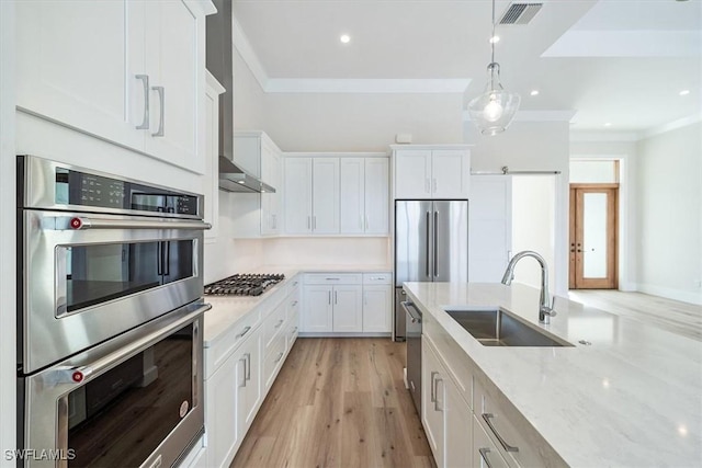 kitchen with decorative light fixtures, white cabinets, appliances with stainless steel finishes, and sink