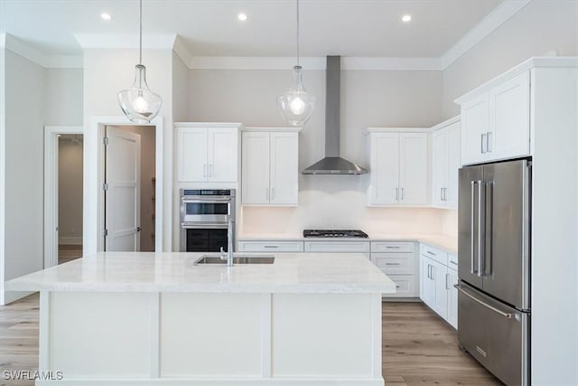 kitchen with stainless steel appliances, white cabinets, and wall chimney range hood