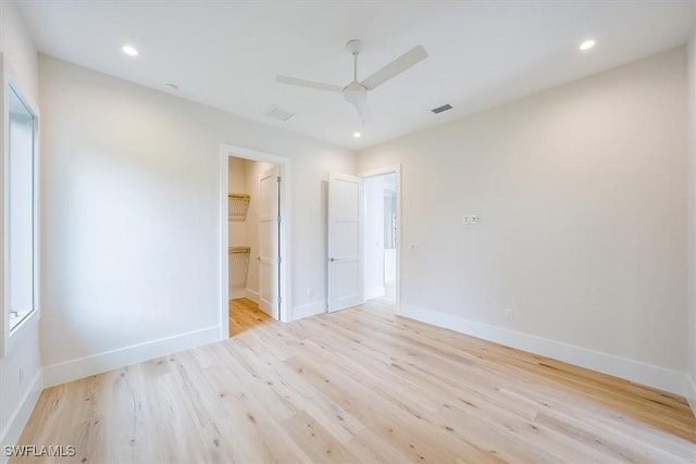 unfurnished bedroom with ceiling fan, ensuite bathroom, and light hardwood / wood-style floors