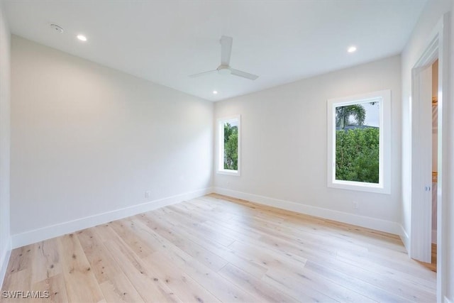 empty room featuring ceiling fan, light hardwood / wood-style flooring, and a healthy amount of sunlight