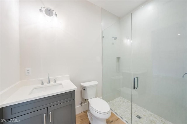 bathroom featuring wood-type flooring, toilet, vanity, and walk in shower