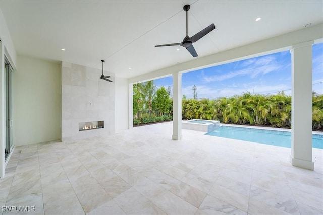 view of pool featuring ceiling fan and a tile fireplace