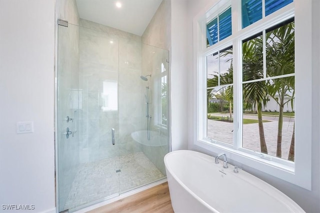 bathroom featuring wood-type flooring and separate shower and tub