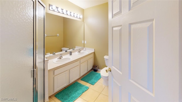 bathroom featuring tile patterned flooring, vanity, toilet, and walk in shower