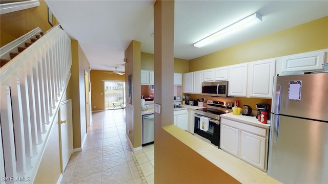 kitchen featuring white cabinetry, appliances with stainless steel finishes, light tile patterned floors, and ceiling fan