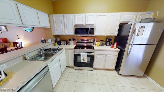 kitchen featuring white cabinetry, sink, light tile patterned floors, and stainless steel appliances