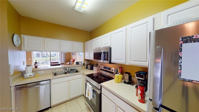 kitchen featuring white cabinetry, sink, light tile patterned flooring, and appliances with stainless steel finishes