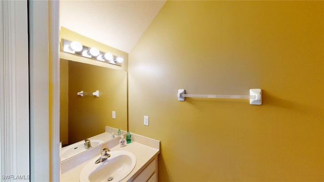 bathroom with lofted ceiling and vanity