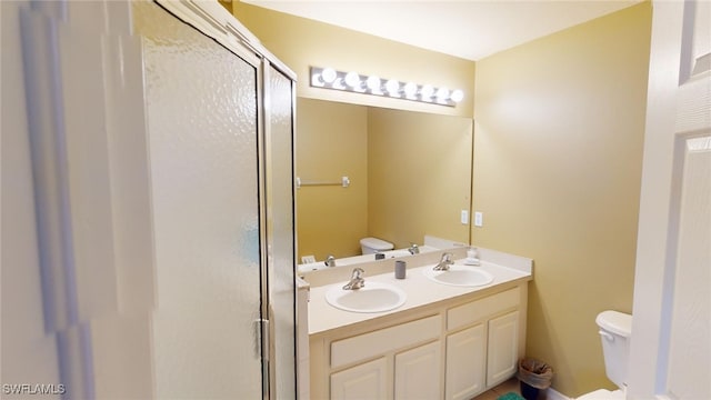 bathroom with walk in shower, vanity, and toilet