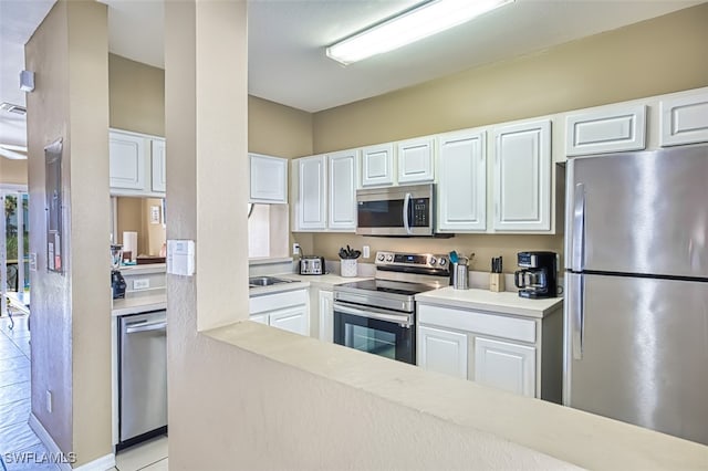 kitchen with visible vents, white cabinets, appliances with stainless steel finishes, light countertops, and a sink