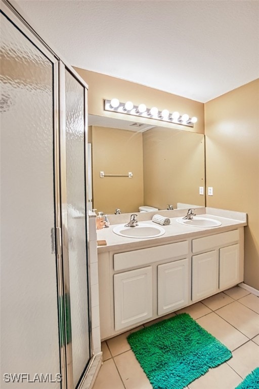 bathroom with a stall shower, tile patterned flooring, and a sink