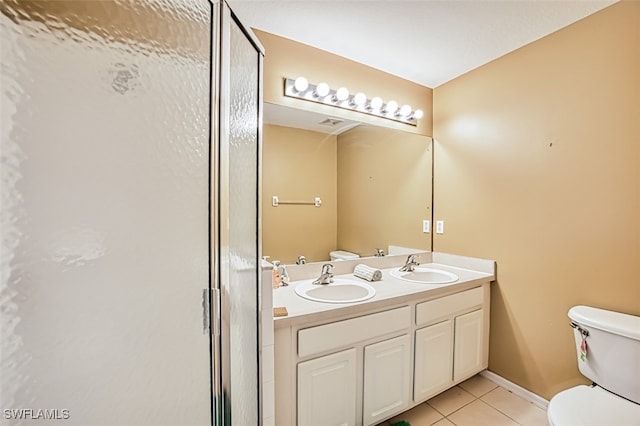 bathroom featuring double vanity, a sink, a shower with shower door, and tile patterned floors