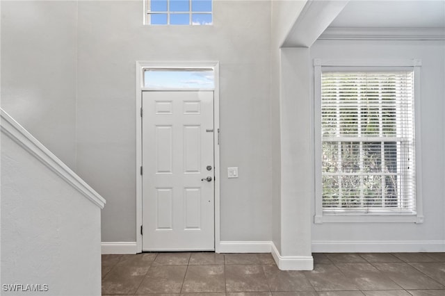 foyer with tile patterned flooring and ornamental molding