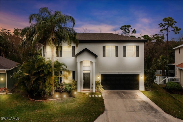 view of front facade with a garage and a lawn