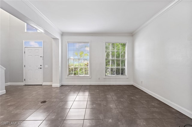 foyer featuring dark tile patterned floors and crown molding