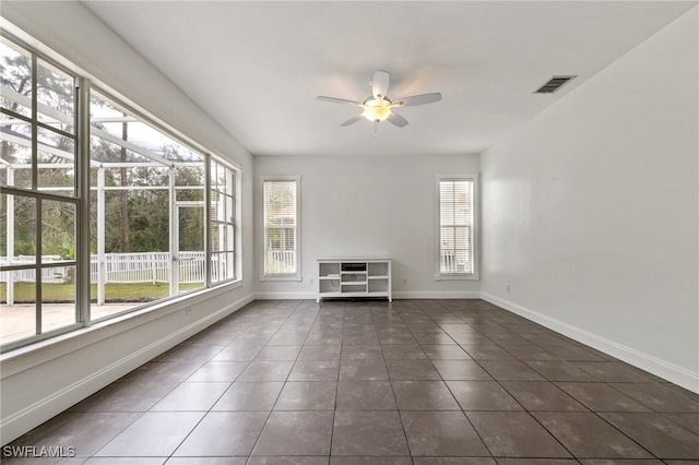 unfurnished living room featuring ceiling fan and dark tile patterned floors