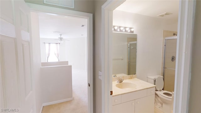 bathroom with an enclosed shower, vanity, toilet, and ceiling fan