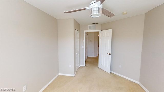 spare room with light colored carpet and ceiling fan