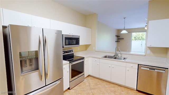 kitchen with stainless steel appliances, sink, pendant lighting, and white cabinets