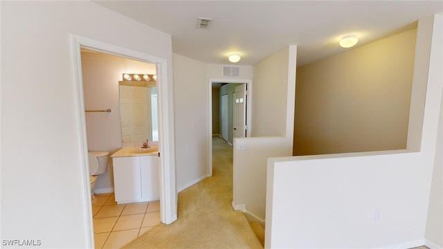 corridor with sink and light tile patterned floors