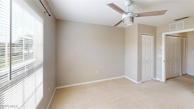 unfurnished bedroom featuring light colored carpet and ceiling fan