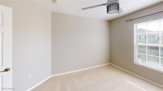 carpeted spare room featuring ceiling fan