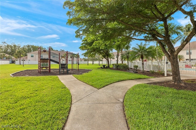 view of home's community with a playground and a lawn