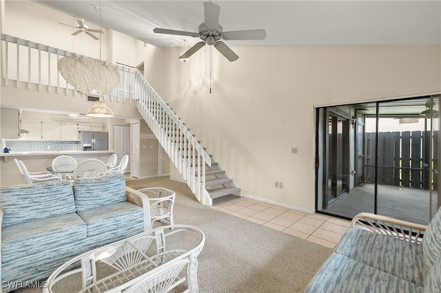 tiled living room with ceiling fan and high vaulted ceiling