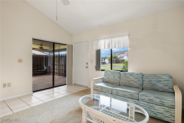 living room with ceiling fan, light tile patterned floors, and vaulted ceiling