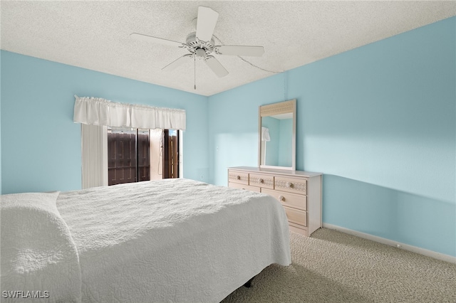 bedroom with a textured ceiling, light colored carpet, and ceiling fan