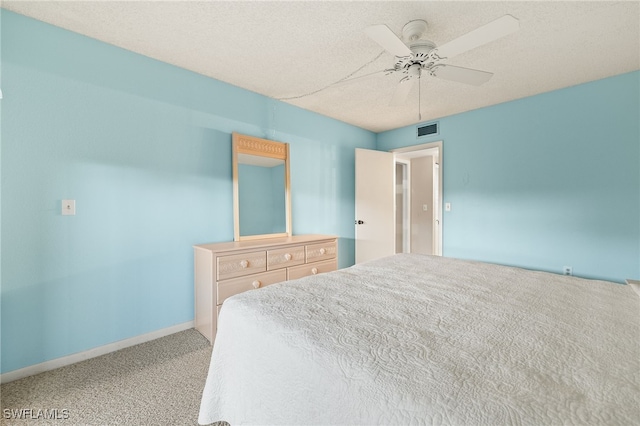 carpeted bedroom with ceiling fan and a textured ceiling