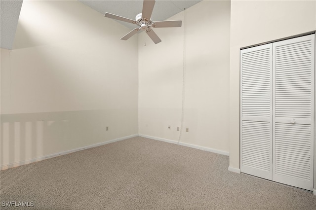 unfurnished bedroom featuring ceiling fan, carpet, and lofted ceiling