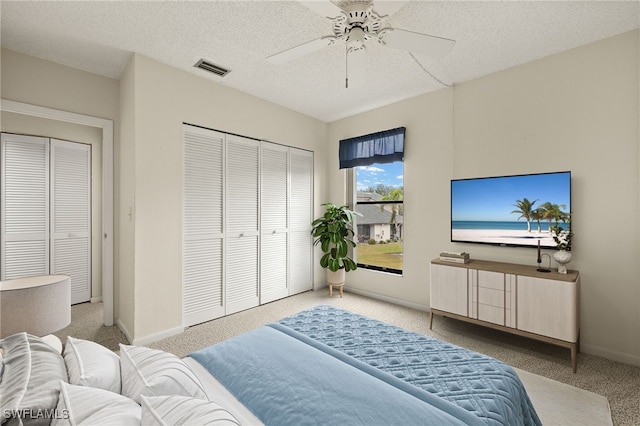 carpeted bedroom featuring ceiling fan and a textured ceiling