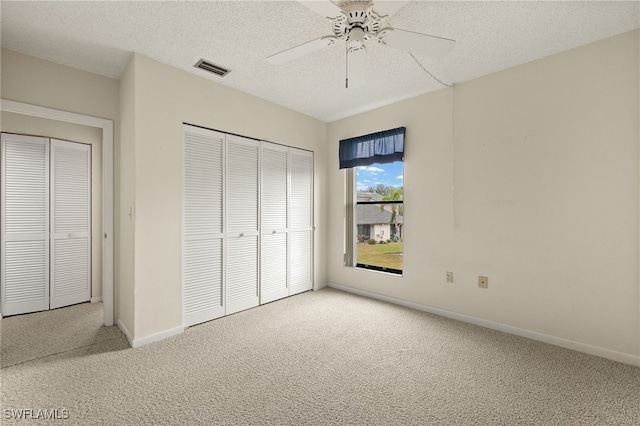 unfurnished bedroom with carpet flooring, a textured ceiling, a closet, and ceiling fan