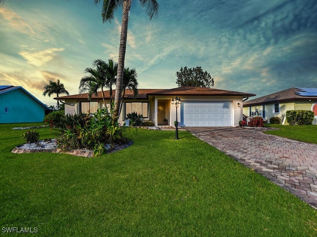 single story home with a garage and a yard