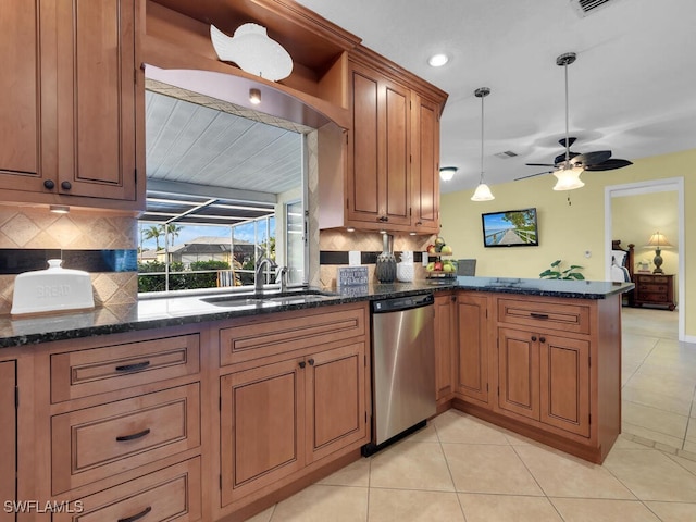 kitchen with decorative light fixtures, sink, kitchen peninsula, light tile patterned floors, and stainless steel dishwasher