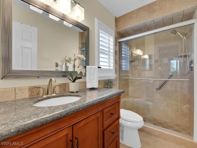 bathroom with a shower with shower door, tile patterned floors, toilet, and vanity