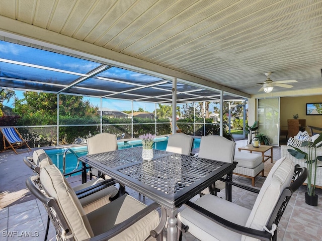 view of patio with ceiling fan and glass enclosure